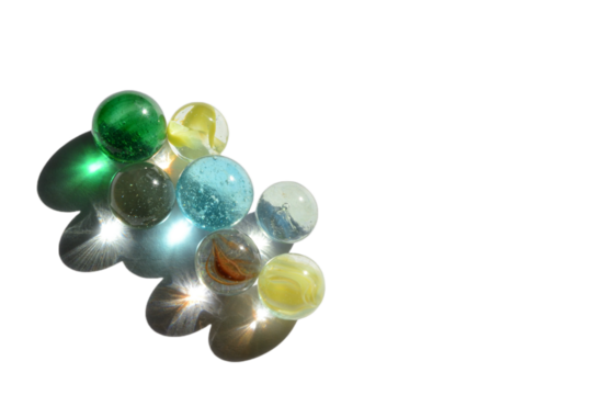 seven marbles with bright light reflecting through colorful glass with no background