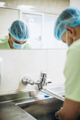 Surgeon washing hands, preparing for the operation