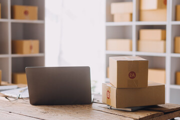 Naklejka premium Startup SME small business entrepreneur of freelance Asian woman using a laptop with box Cheerful success Asian woman her hand lifts up online marketing packaging box and delivery SME idea concept