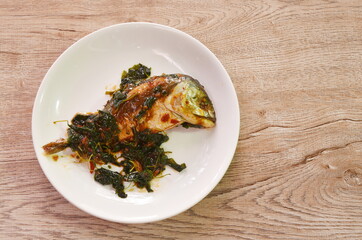 spicy boiled mackerel topping basil in chili sauce on plate