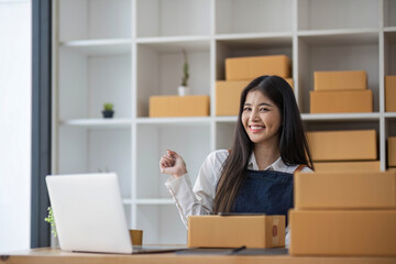 Startup small business entrepreneur SME, asian woman packing cloth in box. Portrait young Asian small business owner home office, online sell marketing delivery, SME e-commerce telemarketing concept.