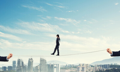 Fototapeta na wymiar Business concept of risk support and assistance with man balancing on rope