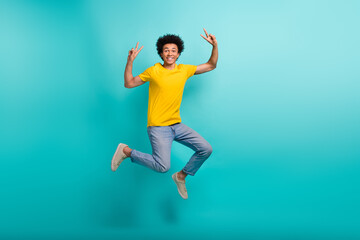 Full size photo of crazy active person jumping hands fingers show v-sign isolated on emerald color...