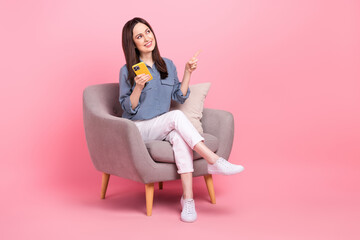 Full portrait photo of sitting chair mature age woman curious look point finger hold iphone cheap...