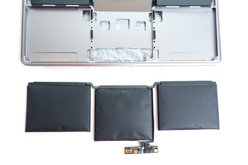 Swollen Laptop Battery Next to Disassembled Laptop