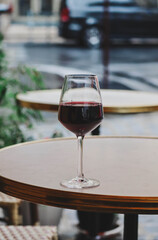 A glass of red wine on the summer terrace of a Parisian restaurant