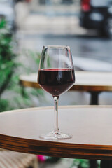 A glass of red wine on the summer terrace of a Parisian restaurant