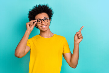 Photo of satisfied good mood guy dressed casual t-shirt glasses directing at discount empty space...
