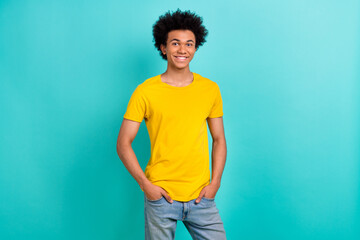 Portrait of satisfied glad young man put hands pockets posing toothy smile isolated on cyan color background