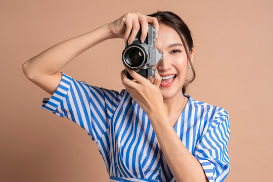 attractive asian female traveller woman enjoy photograph casual lifestyle,woman hold camera taking photo while travel carefree relax vacation, woman travel with happiness cheerful studio shot 