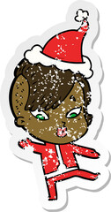 distressed sticker cartoon of a surprised girl in science fiction clothes wearing santa hat