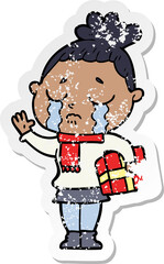 distressed sticker of a cartoon crying woman with christmas gift