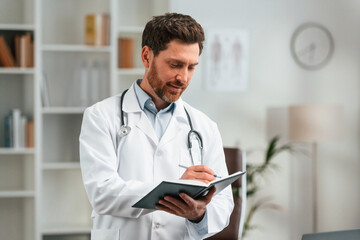 With stethoscope. Doctor in formal clothes is working in the cabinet