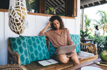 Millennial digital nomad planning content while doing remote job at cafe keeping freelance...