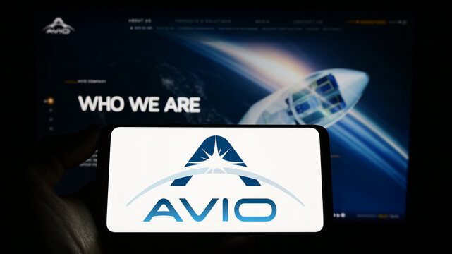 Stuttgart, Germany - 03-25-2023: Person holding smartphone with logo of Italian aerospace company Avio S.p.A. on screen in front of website. Focus on phone display.