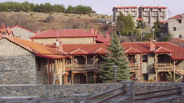 Mountain Lodges traditional village settlement with stone-built houses and red tile rooftops in Agios Athanasios, Greece.