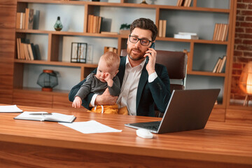 With toddler. Businessman in formal clothes is working indoors