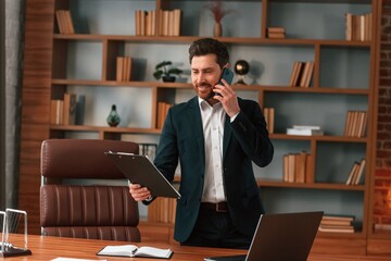 Having phone call. Businessman in formal clothes is working indoors