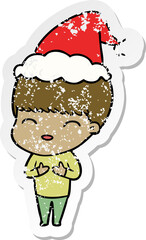 happy distressed sticker cartoon of a boy wearing santa hat