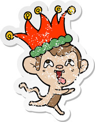 distressed sticker of a crazy cartoon monkey wearing jester hat