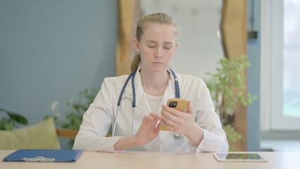Female Doctor Using Smartphone in Clinic