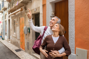 Cheerful Mature Travelers Couple Standing With Backpack On Street Outdoor