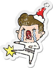 distressed sticker cartoon of a crying man wearing santa hat