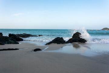 Sea crashing against the stones. Beach shore. Sea with foam