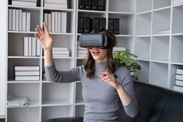 Beautiful woman in virtual reality glasses having fun at home.
