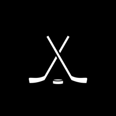 Crossed hockey sticks and hockey puck isolated on black background.