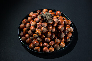 A bunch of hazelnuts on a black background. Nature hazelnuts in shell