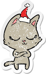 calm distressed sticker cartoon of a cat wearing santa hat