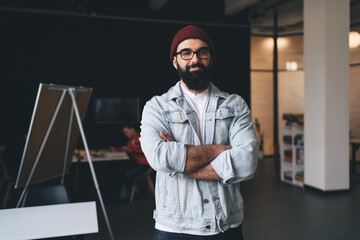 Smiling hipster guy standing in modern office