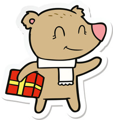 sticker of a friendly bear with xmas gift and scarf