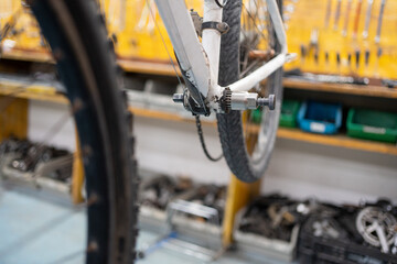 Obraz premium detail of bicycle without pedal hung to fix in the workshop. Interior of bike workshop