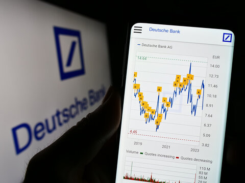 Stuttgart, Germany - 03-25-2023: Person holding cellphone with webpage of German financial company Deutsche Bank AG on screen in front of logo. Focus on center of phone display.