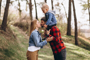 Young family with little son in forest