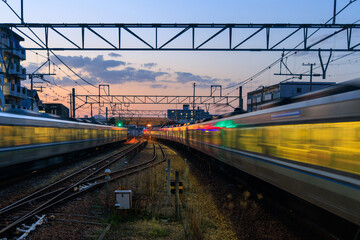 Trains blur down tracks through residential neighborhood at sunset - 586618887