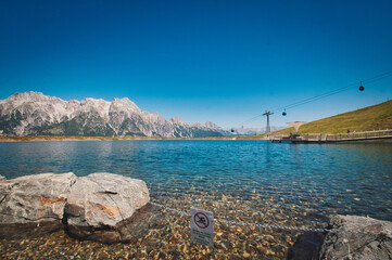 Asitz mountain in the background of the pure and calm lake, and a ropeway, Austria