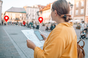 Detail of young tourist woman hands holds city map to trying navigate using map in Krakow city maze on her holidays. Travel and tourism concept. 