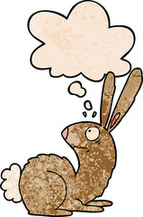 cartoon startled bunny rabbit and thought bubble in grunge texture pattern style