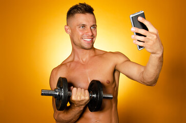 Fototapeta na wymiar Young attractive man with athletic body posing in the studio. Orange background. Sports and healthy lifestyle.