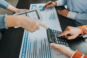 Team of business people meeting to explain financial graph data and marketing plan Group of business people at a meeting assessing the status of business investment and marketing