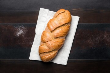 loaf of bread on wooden table, delicious freshly baked bread on kitchen towel on dark brown wooden...