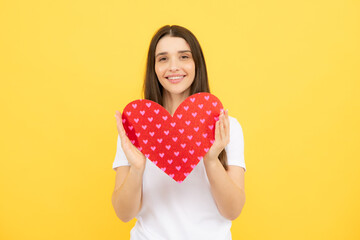 Beautiful amazing woman cuddle paper card heart shape, dreamy isolated on yellow background. Love concept.