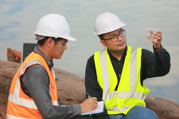 Environmental engineers work at water source to check for contaminants  in water sources and analysing water test results for reuse.World environment day concept.