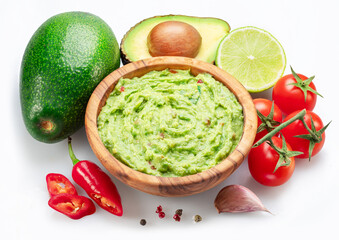 Guacamole bowl and guacamole ingredients isolated on white background. Flat lay.