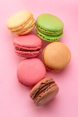 Fototapeta na wymiar Colorful french macarons isolated on pink background. Top view.