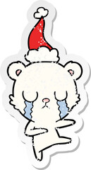 crying polar bear distressed sticker cartoon of a wearing santa hat