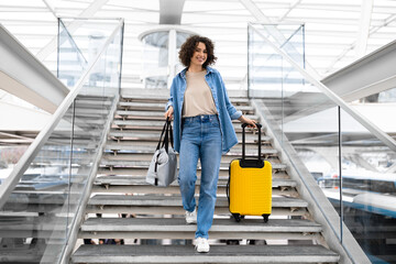 Smiling Beautiful Young Woman Walking With Suitcases On Stairs At Airport